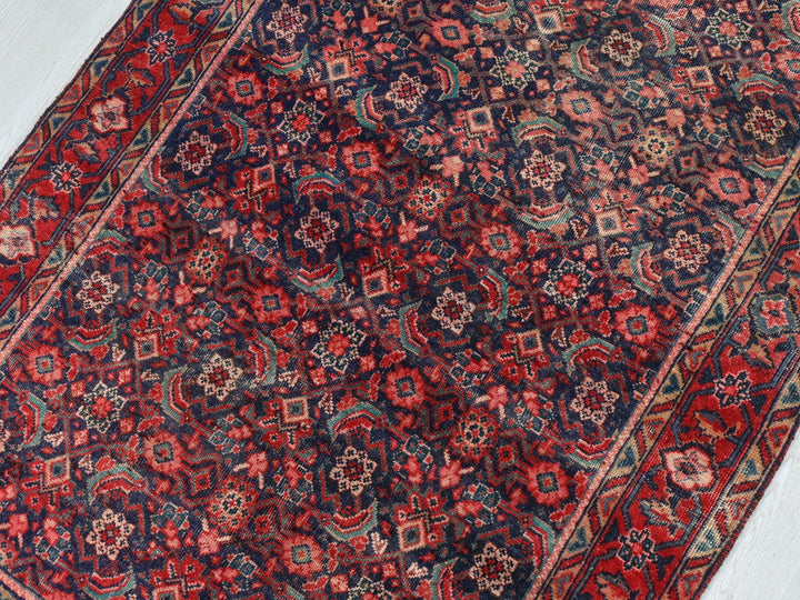 a red and blue rug on a white floor