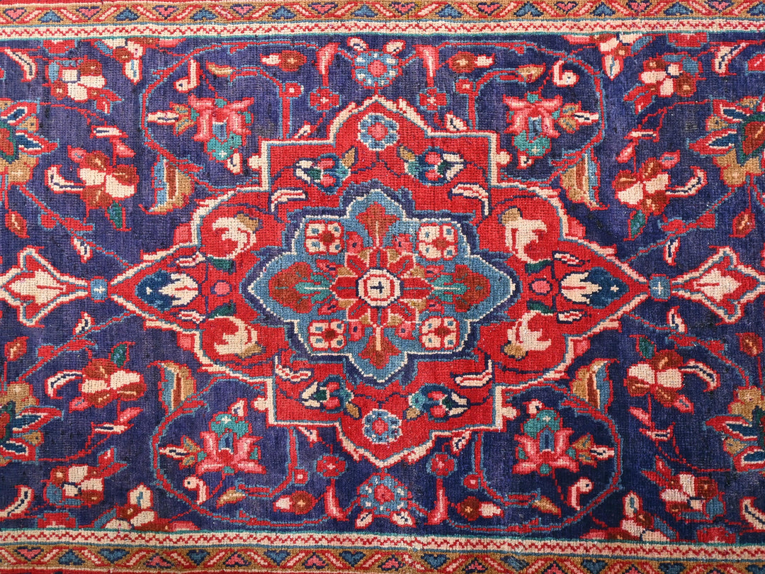 a blue and red rug with a floral design