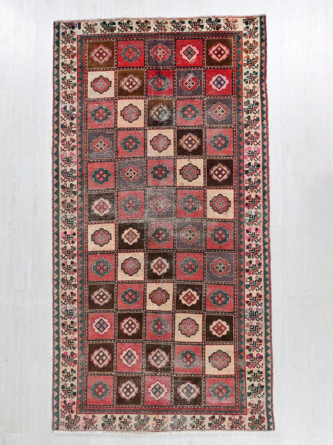 a red and brown rug on a white floor