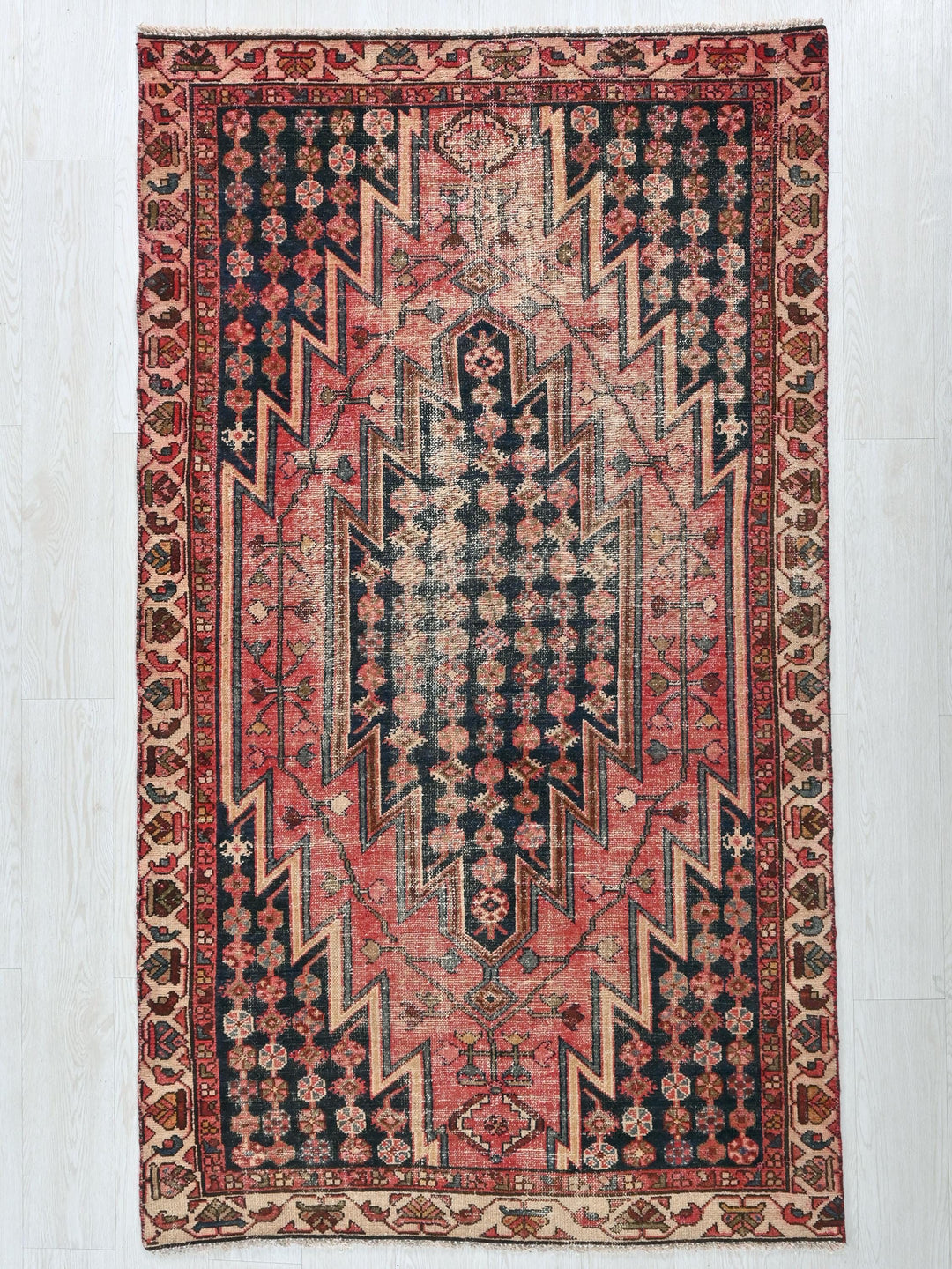 a red and black rug on a white floor
