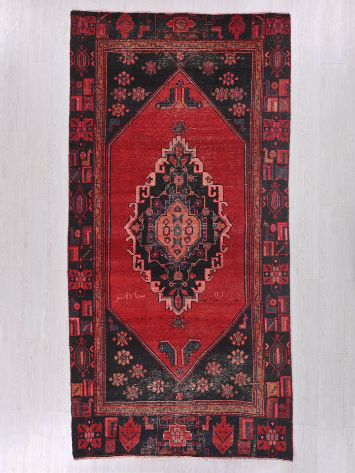 a red and black oriental rug hanging on a wall