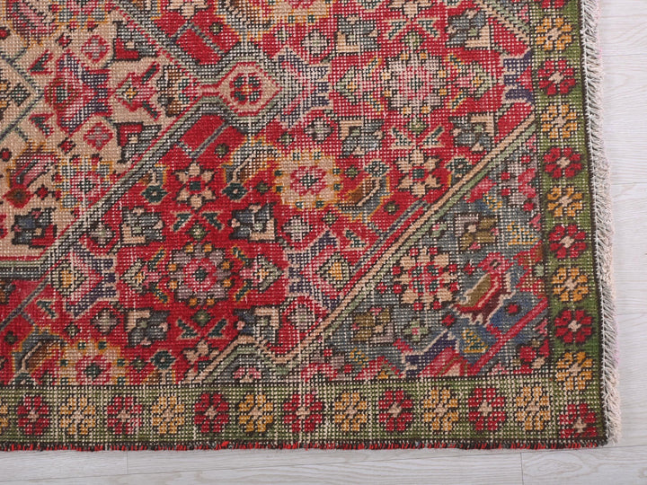 a red and green rug on a white surface