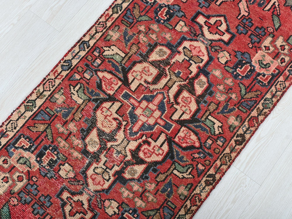 a red oriental rug on a white wooden floor