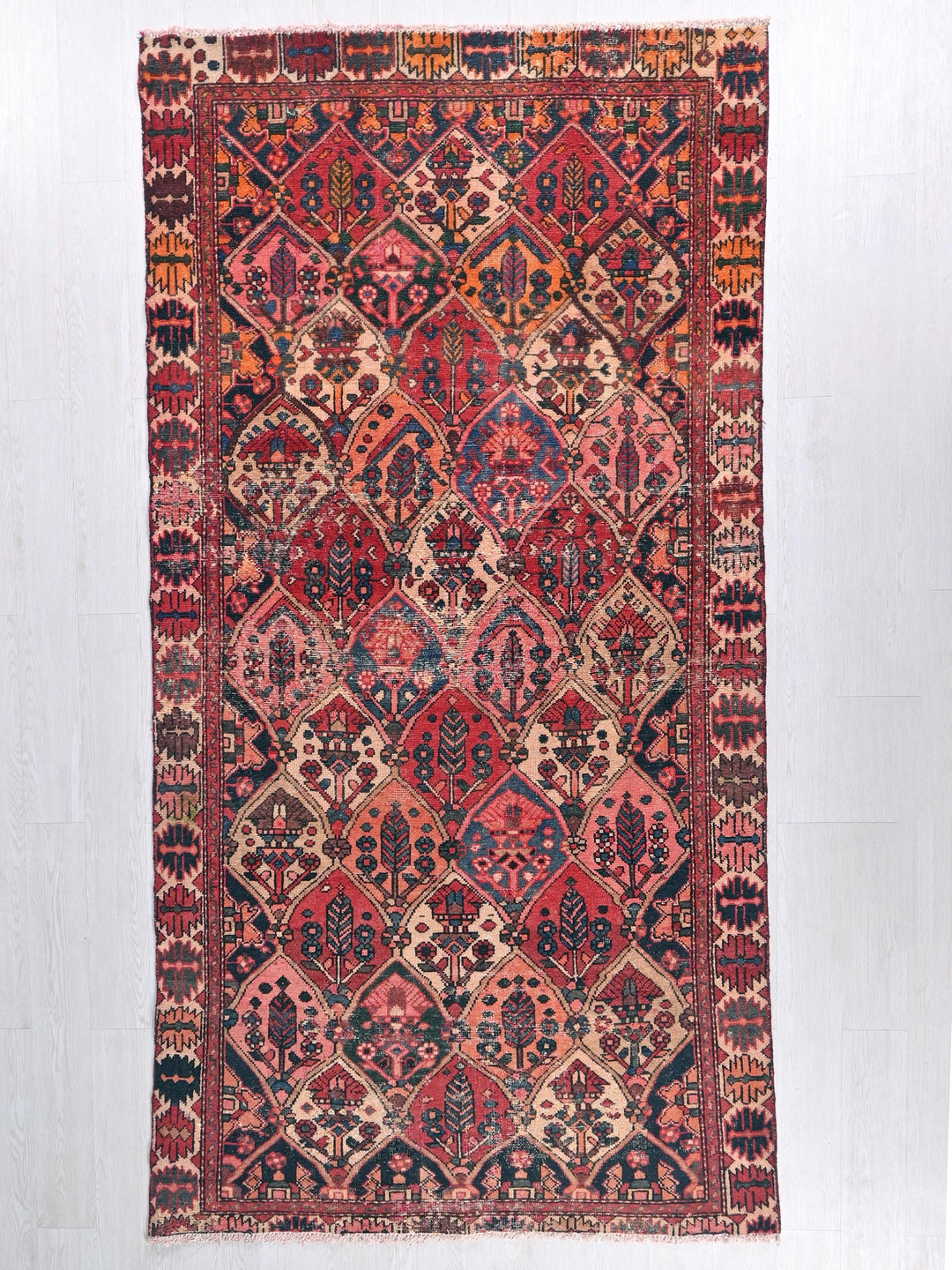 a red and blue rug hanging on a wall