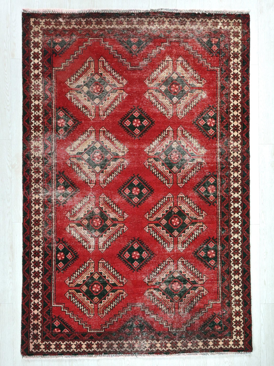 a red rug with a diamond pattern on it