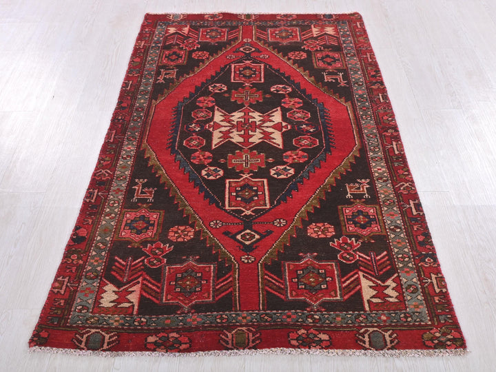 a red and black rug on a white floor
