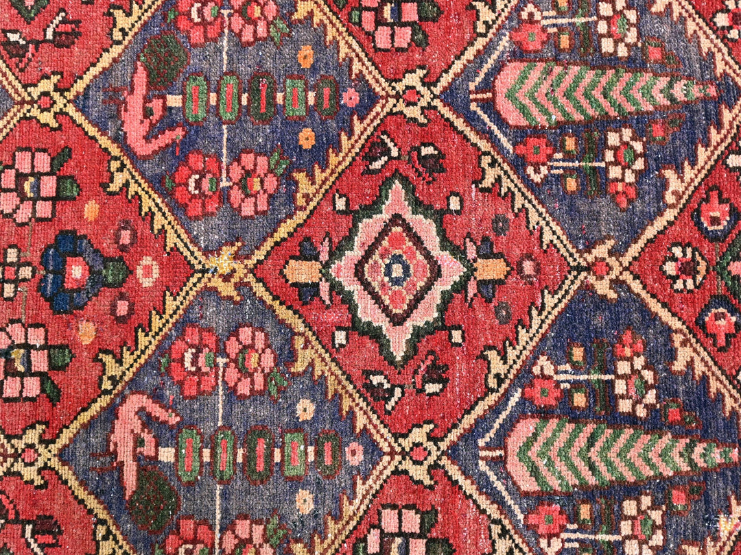 a red and blue rug with a diamond pattern