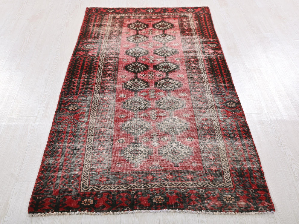 a red and black rug on a white floor