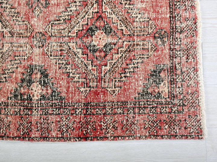 a red and black rug on a white surface