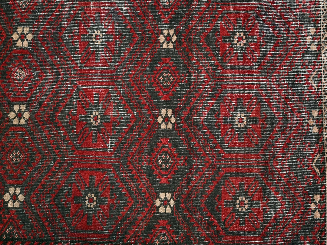 a red and black rug with a white border