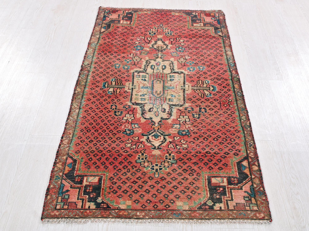 a red oriental rug on a white floor