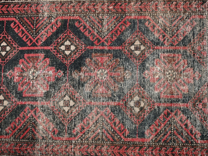 a red and black rug with a pattern on it