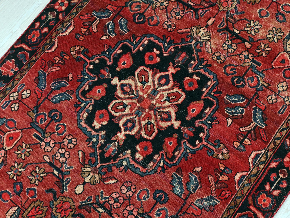 a red rug with a black and red design on it