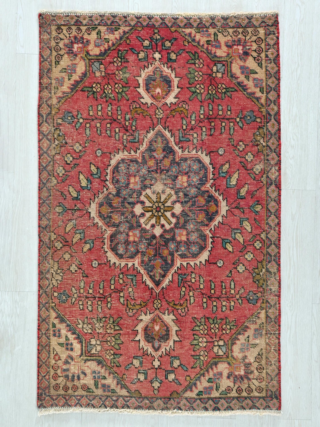 a red rug with a floral design on it