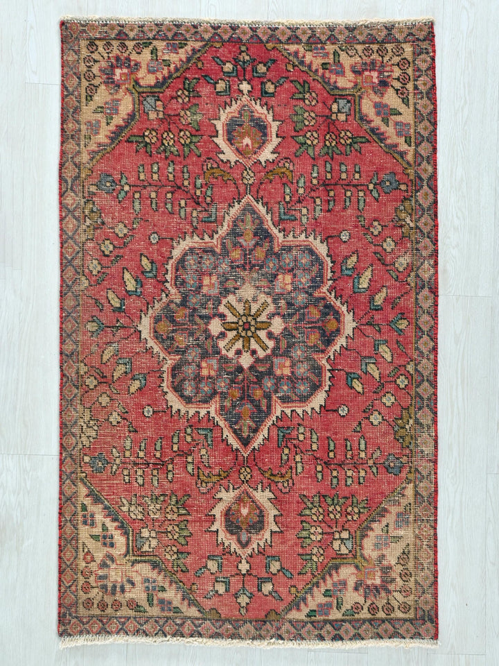a red rug with a floral design on it