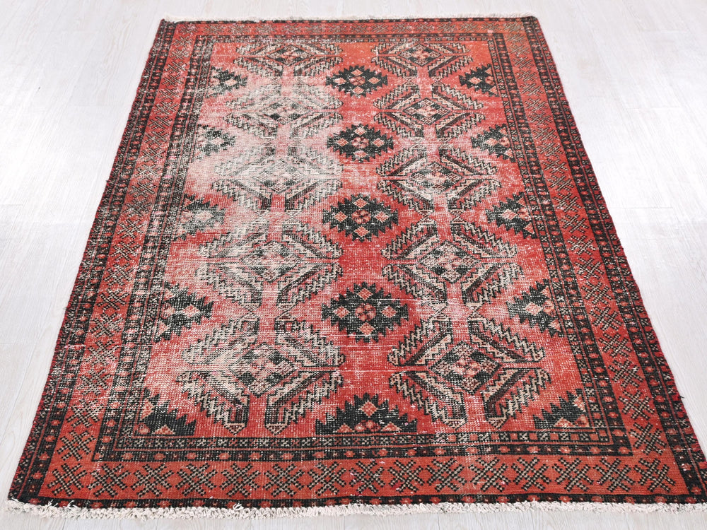 a red and black rug on a white floor