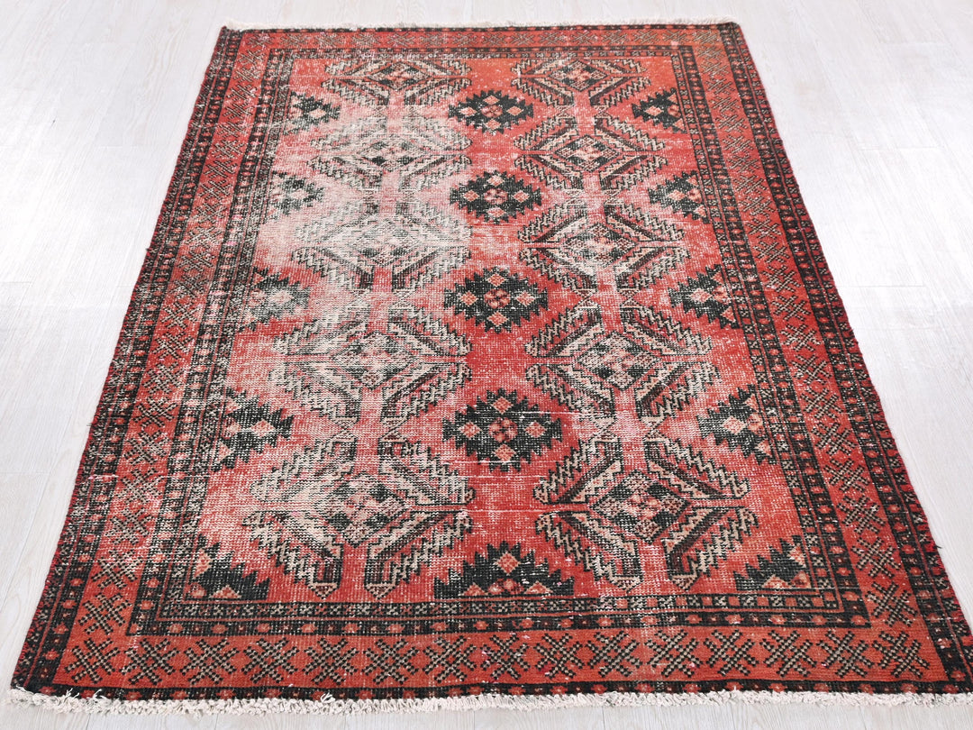 a red and black rug on a white floor