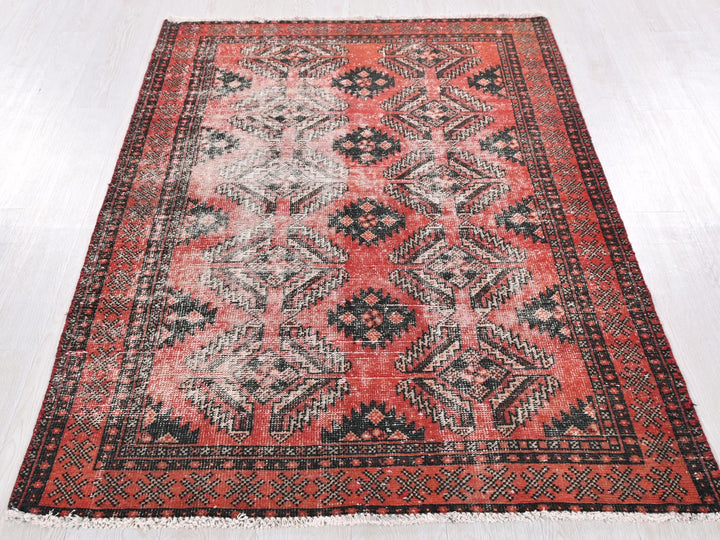 a red and black rug on a white floor