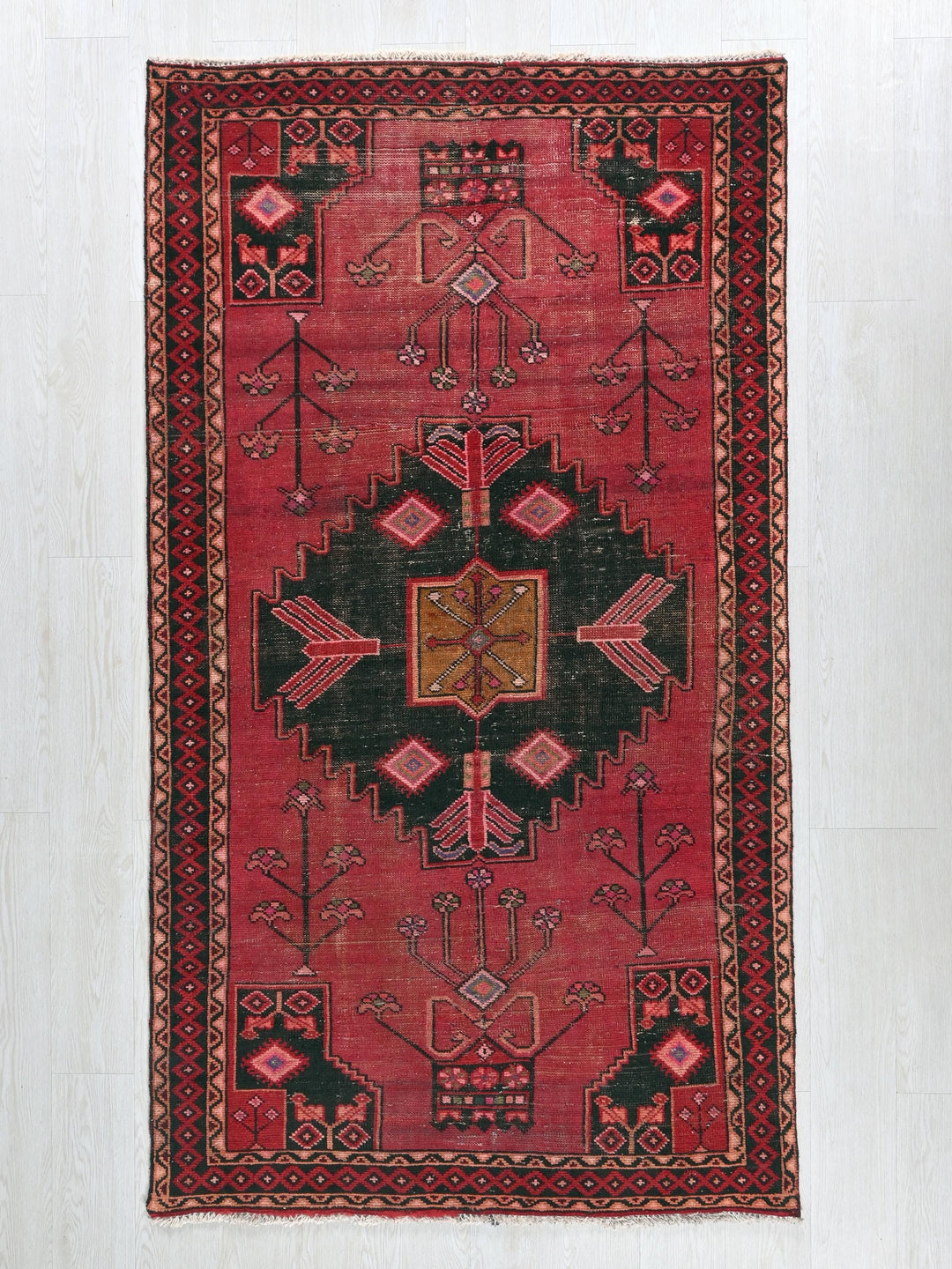 a red rug with black and red designs on it