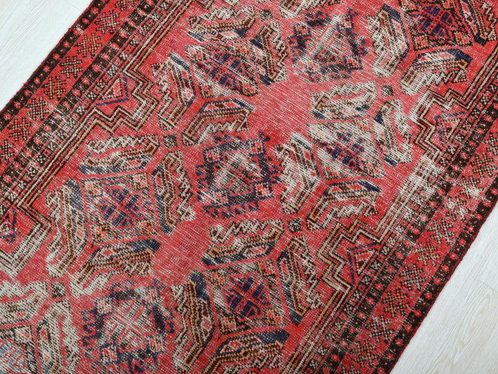a red and blue rug on a white floor