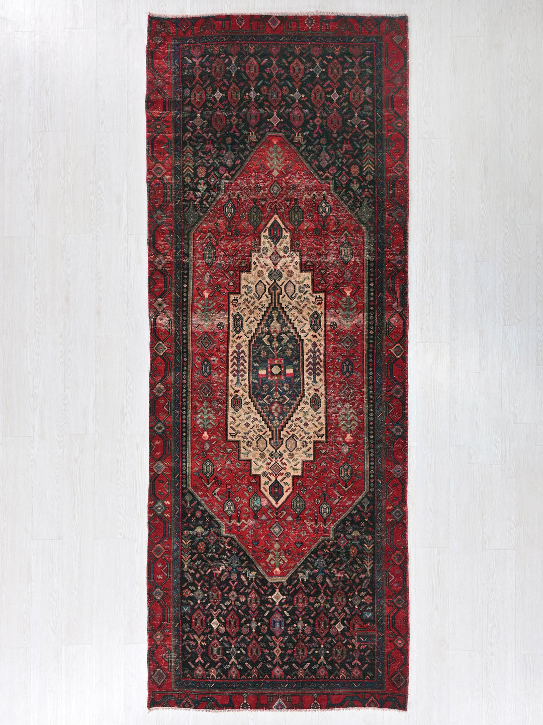 a red rug hanging on a white wall