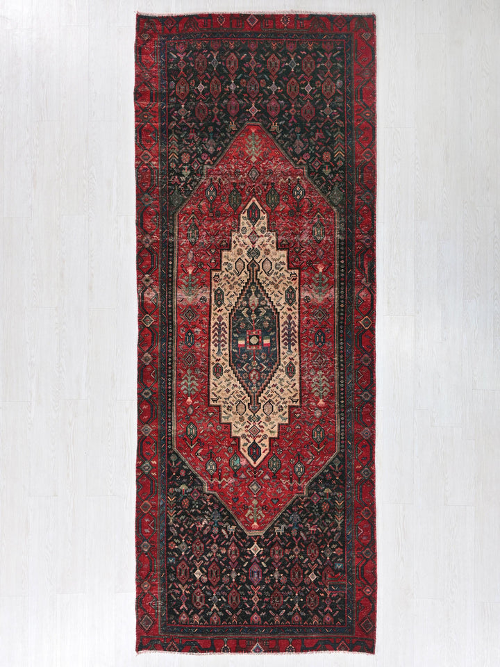 a red rug hanging on a white wall