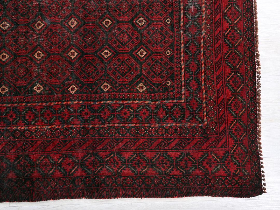 a red and black rug on a white surface
