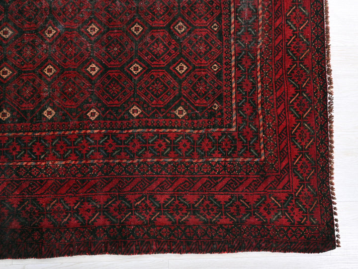 a red and black rug on a white surface