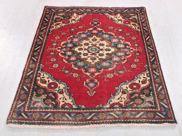 a red rug on a white wooden floor