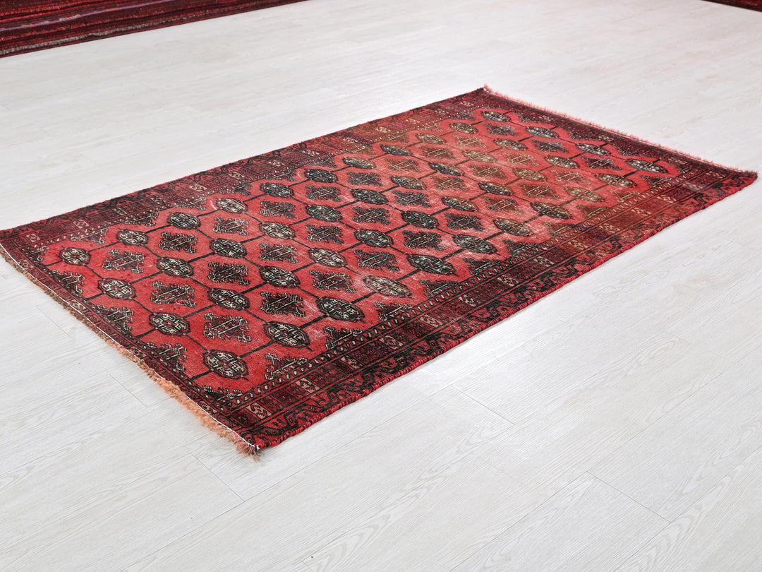 a red and black rug on a white floor