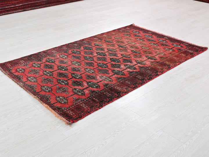a red and black rug on a white floor