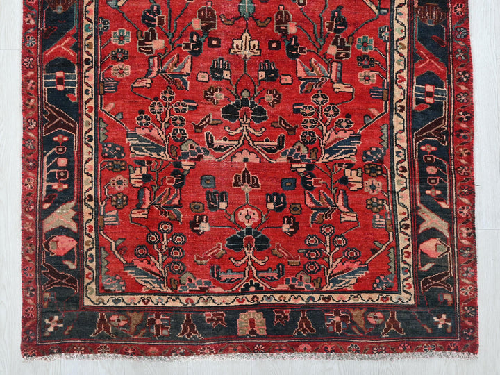a red rug with a black border on a white wall