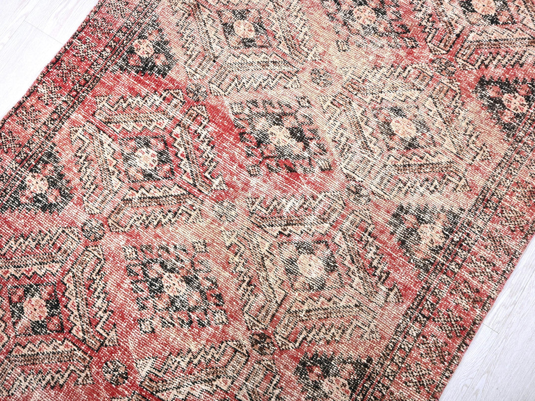 a red and black oriental rug on a white floor
