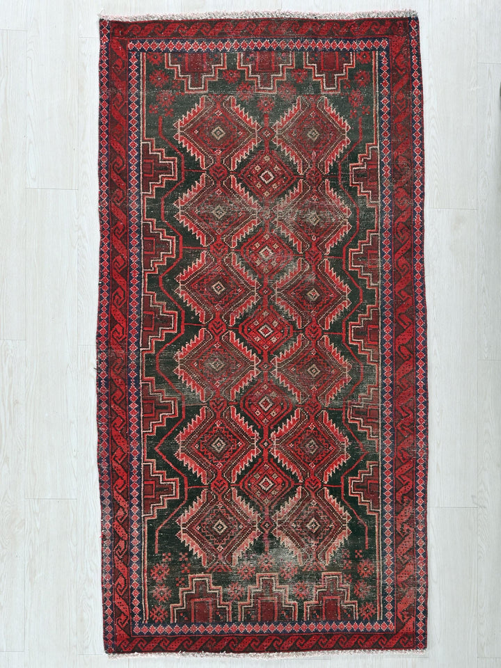 a red and black rug on a white floor