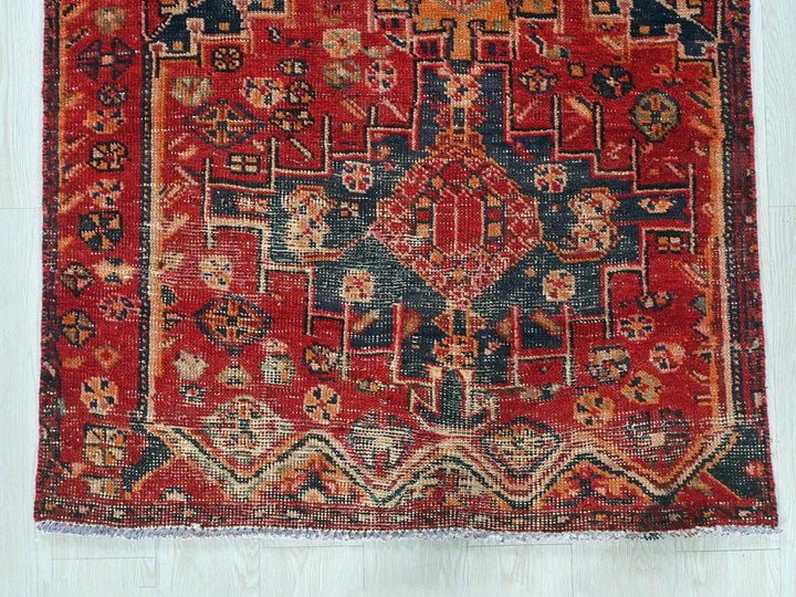 a red rug with a blue and orange design