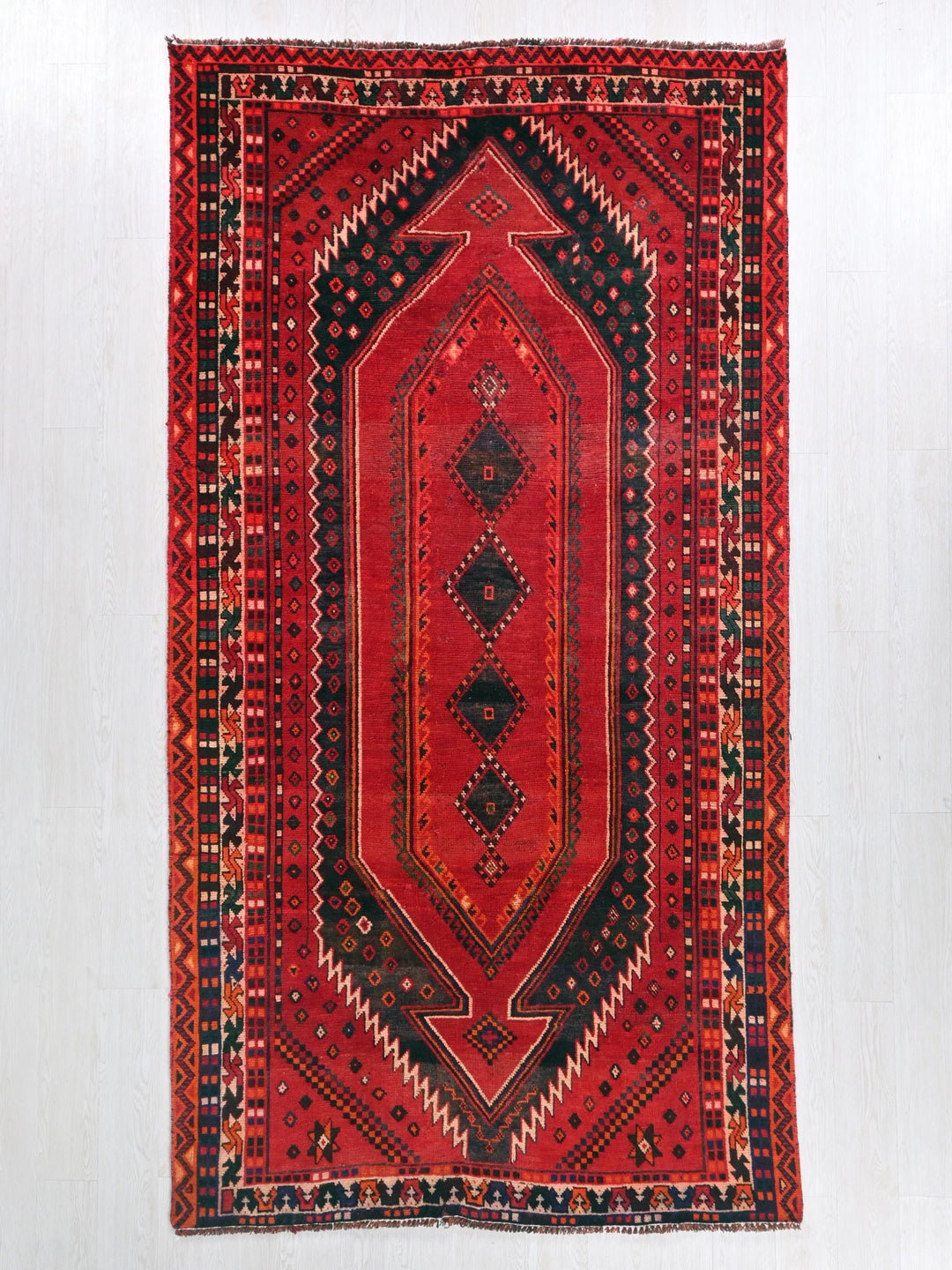 a red rug hanging on a wall