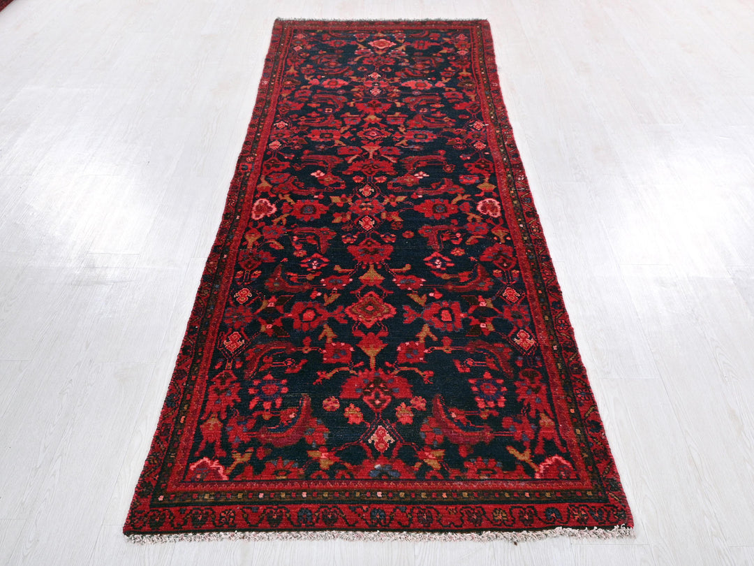 a red and black rug on a white floor