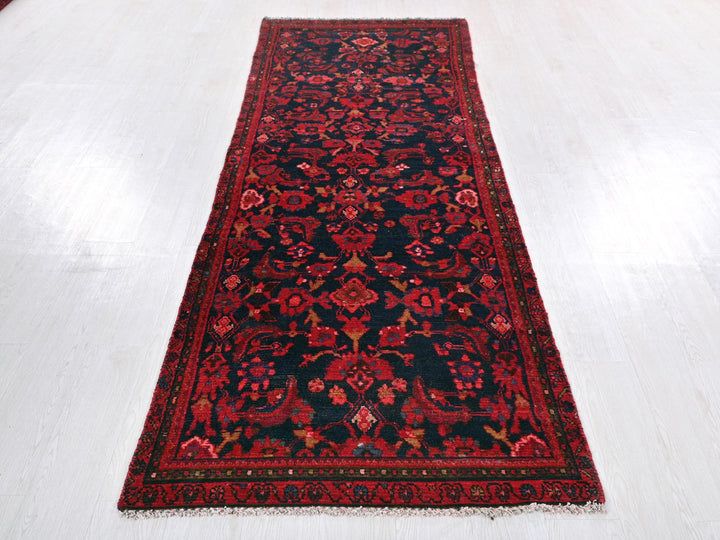 a red and black rug on a white floor