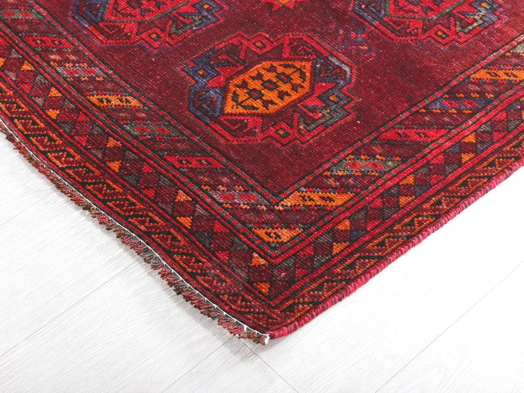 a close up of a red rug on a white floor