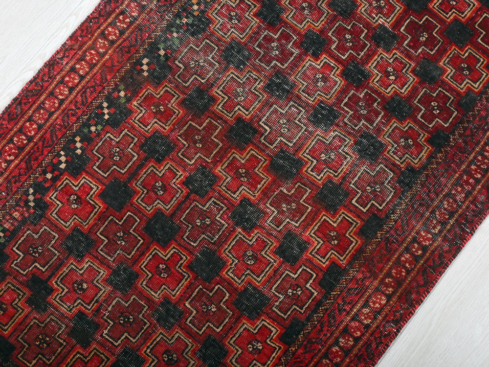 a red and black rug on a white floor