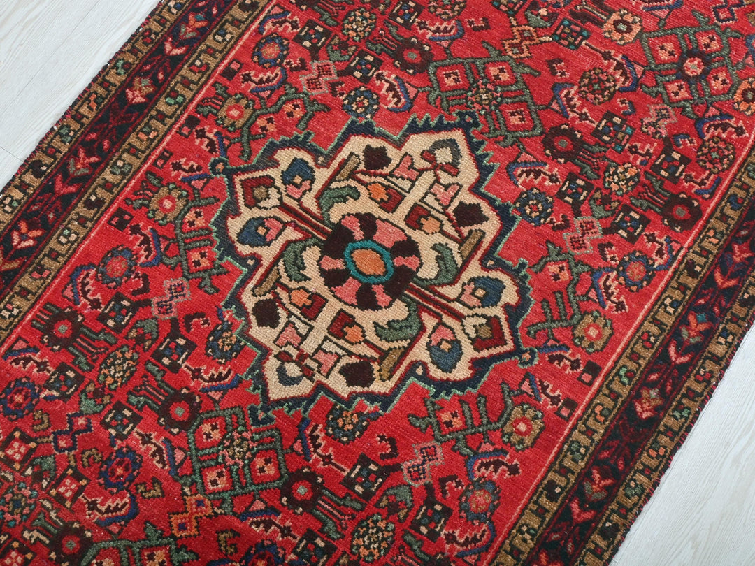 a red rug with a floral design on it