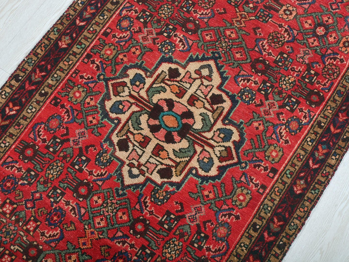 a red rug with a floral design on it