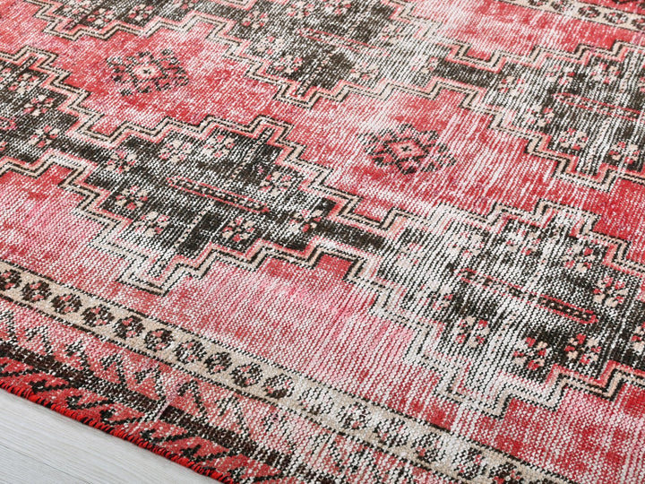 a red rug with a black and white design on it