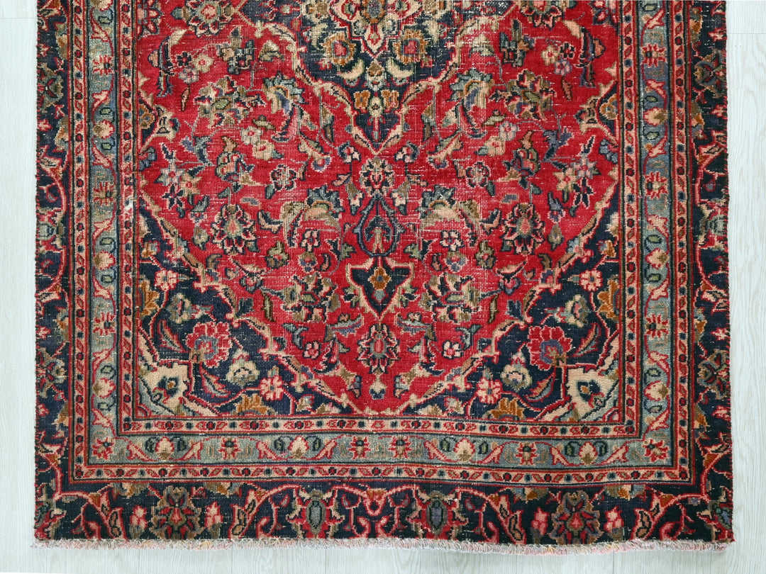 a red and blue rug on a wooden floor