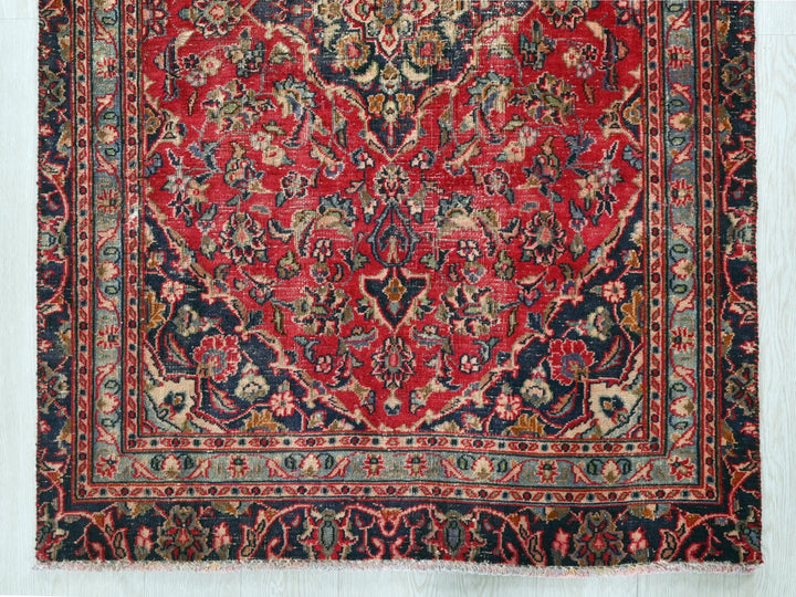 a red and blue rug on a wooden floor
