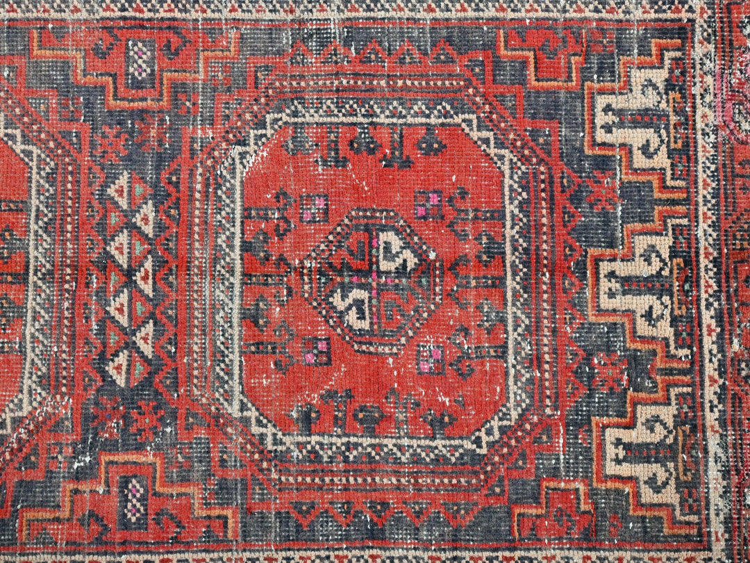 a red and blue rug with an intricate design