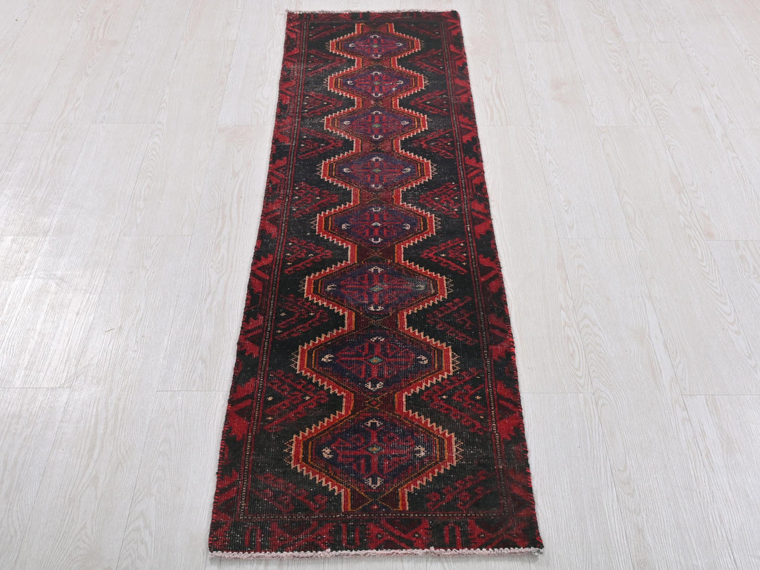 a red and black runner rug on a white floor