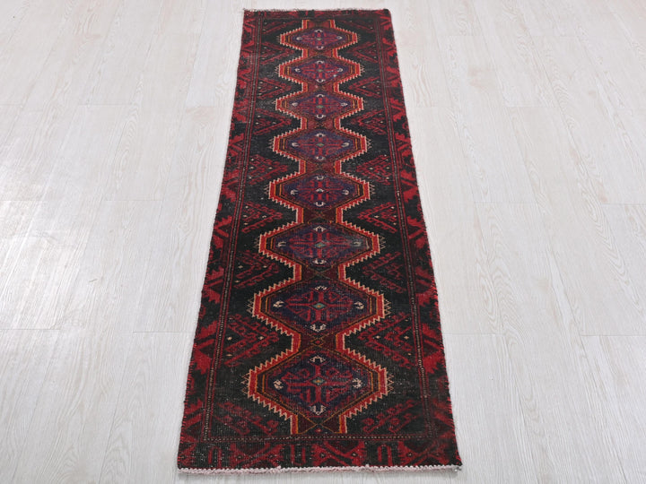 a red and black runner rug on a white floor