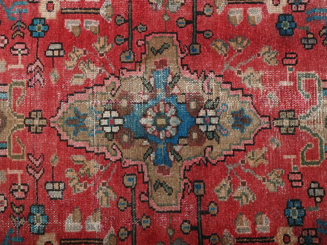a red rug with a floral design on it