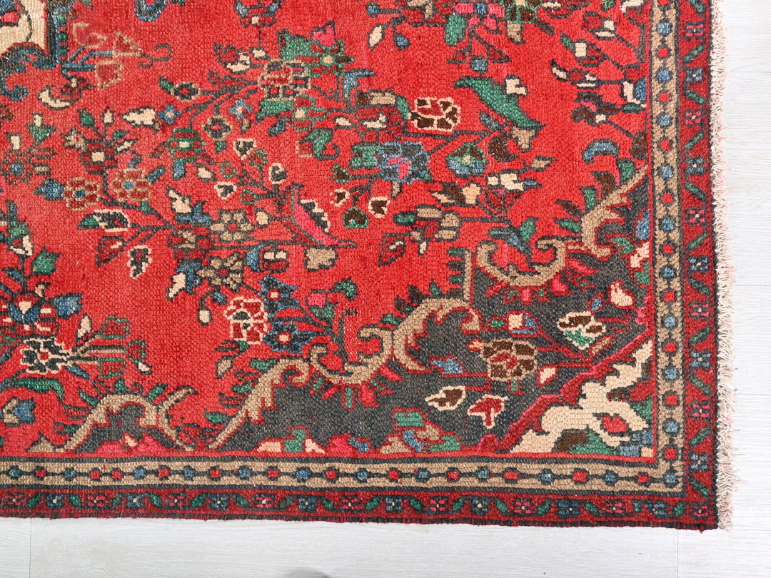 a red rug with a floral design on it